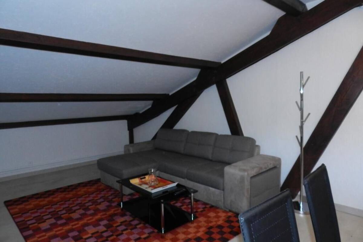 A loft-style room with a gray sofa, a patterned rug, and a modern coffee table.