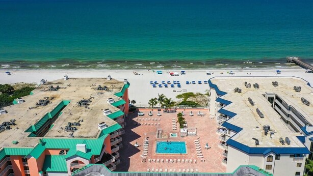 Un complexe hôtelier doté d’une piscine, d’une plage et offrant une vue sur l’océan.