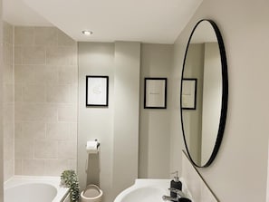 A modern bathroom with two sinks, a large mirror, and framed artwork on the walls. - Beautiful 1-bed Apartment in York (York)