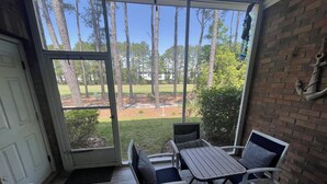 A covered patio with a table and chairs, a view of a lawn and trees, and a brick wall. - PROMO 5% WEEKLY DISCOUNT!
New Listing Golfer Haven w/Patio Pool & Beach shuttle (North Myrtle Beach)