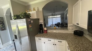 A modern kitchen with white cabinets, a stainless steel refrigerator, a coffee maker, and a toaster on the countertop. - PROMO 5% WEEKLY DISCOUNT!
New Listing Golfer Haven w/Patio Pool & Beach shuttle (North Myrtle Beach)