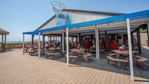 A beachside restaurant with outdoor seating and a covered area. - Myrtle Beach Resort Unit 5110 - Ideal Beach Getaway (Myrtle Beach)