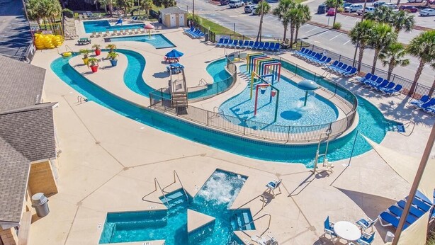 A swimming pool area with multiple lanes, lounge chairs, and a water slide. - Myrtle Beach Resort Unit 5110 - Ideal Beach Getaway (Myrtle Beach)