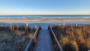 A wooden boardwalk leading to a beach with a clear sky. - Myrtle Beach Resort Unit 5110 - Ideal Beach Getaway (Myrtle Beach)