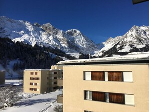 Un hotel con vista a la montaña, que cuenta con un edificio moderno de varios pisos y amplias ventanas.