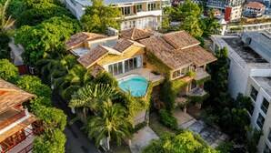 A residential area with a swimming pool, multiple houses, and lush greenery. - Teetara Villa Patong (Patong)