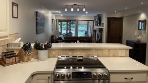 A modern kitchen with a central island, stainless steel appliances, and a view to the living area. - Perfect location off 4 o'clock run, Walk to Mainstreet, Ski-In, Shared Hot Tub (Breckenridge)