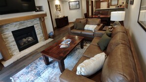 A living room with a fireplace, leather sofas, a coffee table, and a flat-screen TV mounted on the wall. - Perfect location off 4 o'clock run, Walk to Mainstreet, Ski-In, Shared Hot Tub (Breckenridge)