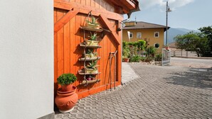 A building with a wooden facade, a metal gate, and potted plants.