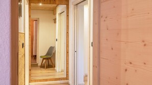 Un corridoio stretto con pavimento in legno e porte che conducono a diverse stanze.