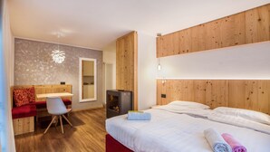 Ein Hotelzimmer mit einem Bett, einem Schreibtisch, einem Sessel, einem kleinen Heizgerät und einem Spiegel.