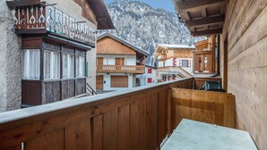 Ein Holzbalkon mit Blick auf einen Berg und angrenzende Gebäude.