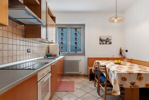 Eine Küche mit Herd, Spüle und einem Fenster mit Vorhängen.