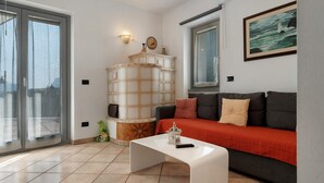 A modern living room with a sofa, a coffee table, a decorative cabinet, and a painting on the wall.