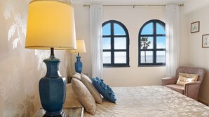 A room with a bed, two windows, a chair, and a lamp. - Luzias Apartment with Sea View, Wi-Fi & Balcony (Funchal)