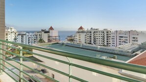 A residential building with multiple balconies, a rooftop terrace, and a view of the sea. - Holiday Apartment Oliveira Atlantic View with Sea View, Wi-Fi & Balcony (Funchal)