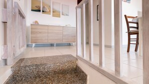 A modern interior with a wooden cabinet, a stone bench, and a wooden chair. - Apartment "Vista Corsica" on Isola Rossa with Sea View & Terrace (Isola Rossa)