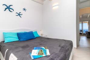 Quarto com cama, mesa de cabeceira e parede decorada com estrelas-do-mar.
