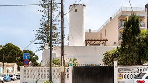 A gated hotel entrance with a white facade, a tall cylindrical structure, and a sign indicating 'HOTEL NA FORANA.' - Vacation Home "Molino Son Moll" with Pool, Wi-Fi, Balcony, Garden & Terrace (Cala Ratjada)
