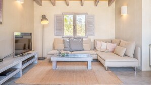 A living room with a sofa, a coffee table, a TV, and a lamp. - Holiday Home 'Cascada' with Mountain View, Private Pool and Wi-Fi (Costitx)