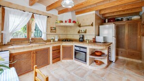 Une cuisine avec des armoires en bois, une cuisinière, un évier et un réfrigérateur.