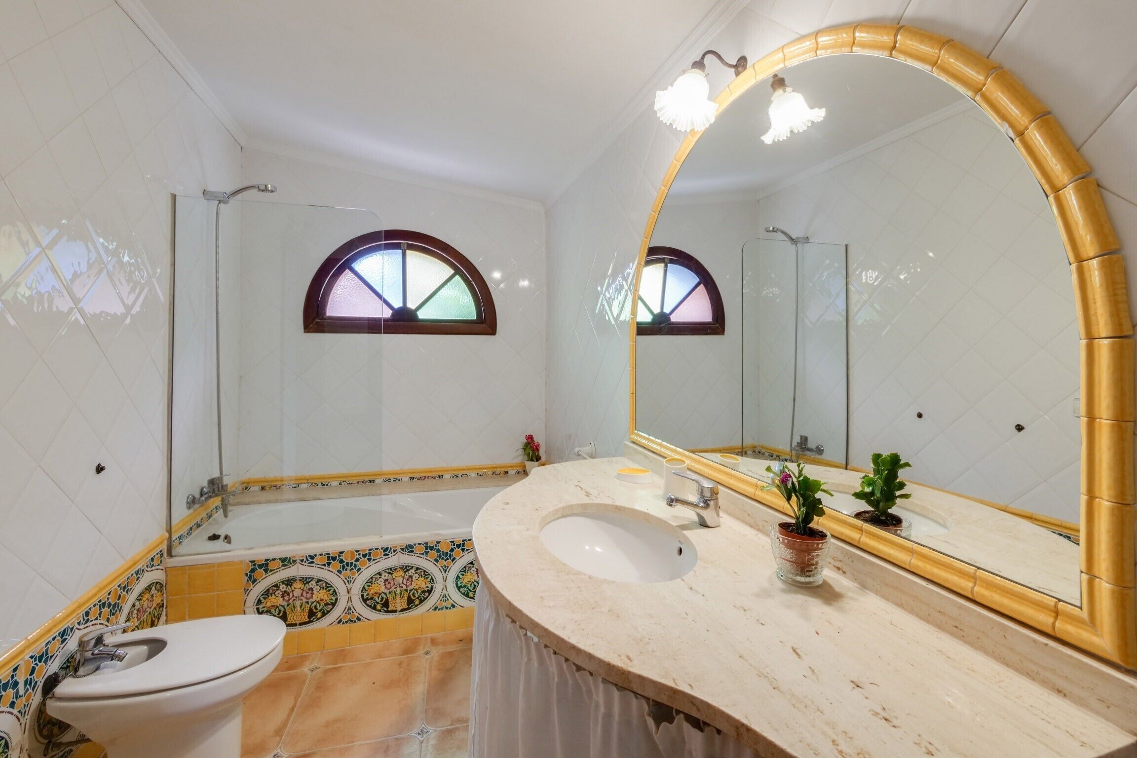 Un baño con una bañera, un inodoro, un lavabo y un espejo grande.