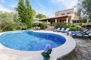 A swimming pool with lounge chairs and a stone house with a tiled roof. - Finca Can Reure with Mountain View, Wi-Fi Pool, Garden & Terrace (Inca)