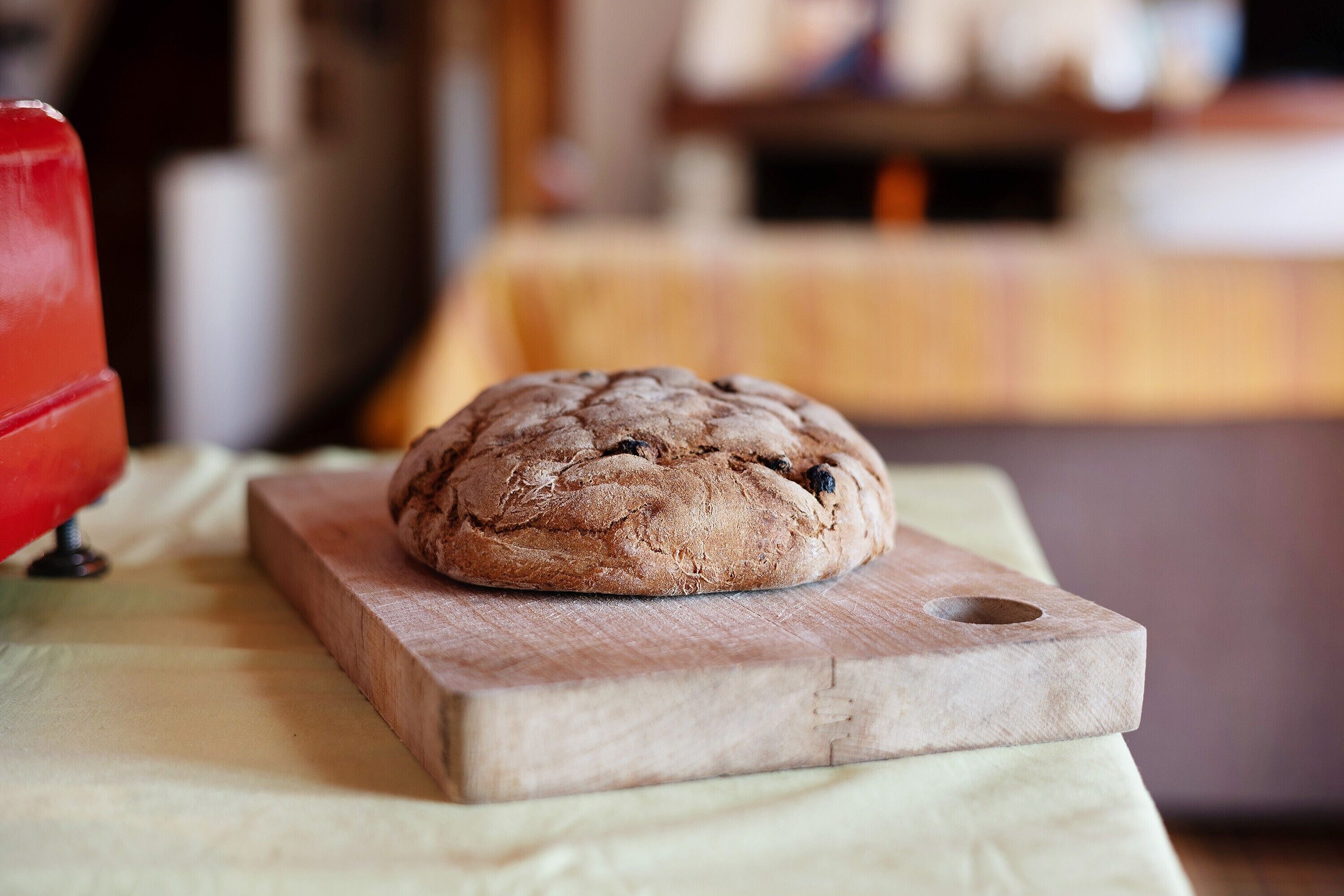 A loaf of bread on a wooden cutting board.