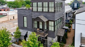 Un edificio residenziale a più piani con un balcone e un piccolo patio.