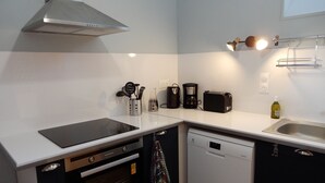A compact kitchen with a stove, oven, dishwasher, and a coffee maker. - Castle outbuilding sleeps 6 (MORLAIX)