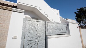 Un edificio blanco con una escalera que lleva al segundo piso.