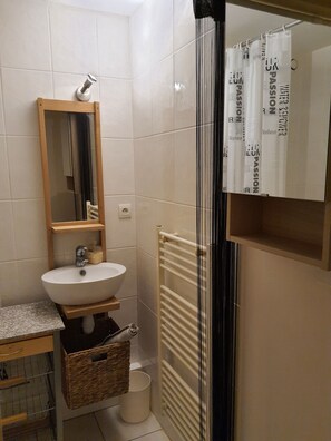 Chuveiro, toalhas de banho, sabonete, papel higiênico