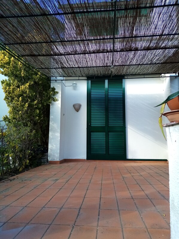 Relax in this serene outdoor space, surrounded by lush greenery and a decorative accent on the wall.
