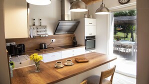 Una cocina moderna con encimeras de madera, luces colgantes y vistas al exterior.