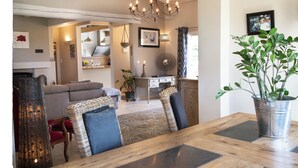 Un comedor con una mesa de madera, sillas y una planta en maceta.