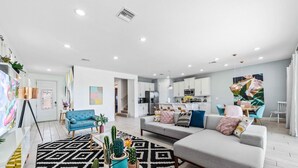 A modern living room with a sofa, a coffee table, and a patterned rug. - Pool /Spa/Games Room/Movie Room/10 mins Disney/Restaurant and Bar/Modern /Chic (Kissimmee)