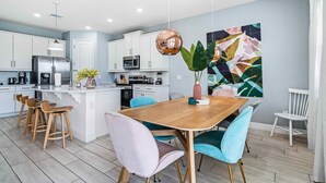 A modern kitchen with white cabinets, stainless steel appliances, and a central island. - Pool /Spa/Games Room/Movie Room/10 mins Disney/Restaurant and Bar/Modern /Chic (Kissimmee)