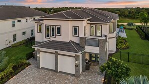 Un immeuble résidentiel à deux étages, doté d'un garage, de détails en pierre et d'une pelouse bien entretenue.