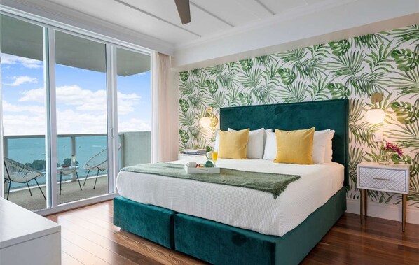 A bedroom with a large bed, a balcony with chairs, and a view of the sea. - Panoramic Views Residence with Private Balcony (Miami)