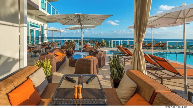 A rooftop lounge with outdoor seating, umbrellas, and a pool. - Panoramic Views Residence with Private Balcony (Miami)