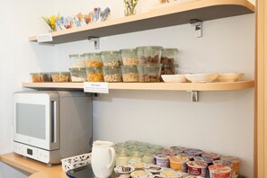 A kitchenette with a microwave, cereal containers, and yogurt tubs. - Double room with extra bed - Baltic Hotel in Lübeck (Lübeck)