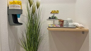Et receptionsområde med skumdoser, en plante og kaffestation.