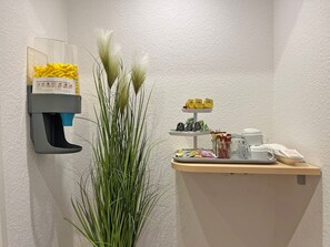 A reception area with a foam dispenser, a plant, and a coffee station. - Double room with extra bed - Baltic Hotel in Lübeck (Lübeck)