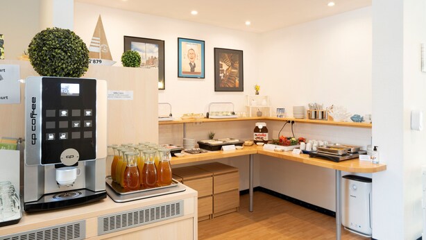 Et moderne køkken med kaffemaskine, juicebar og et udvalg af madvarer på disken.