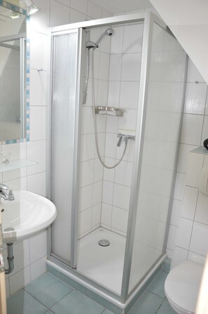 A modern bathroom with a glass-enclosed shower, a white sink, and a toilet. - Muschelstrand 2-3 Pers - Fewo Vermietung Carmen Sagner (Baabe)