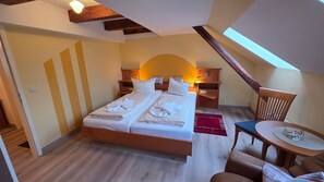 Une chambre à coucher avec un lit, des tables de chevet, une chaise et une petite table.