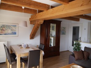 Ein Essbereich mit Holztisch und Stühlen, einem Schrank und einer Couch.