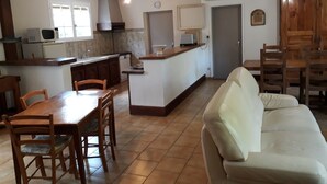 A compact living space with a kitchen, dining area, and a sofa. - Peace and quiet on a private island in a bucolic setting. (Barro)