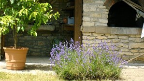 A stone building with a brick oven, a potted tree, and lavender bushes. - Peace and quiet on a private island in a bucolic setting. (Barro)