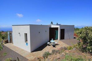 Un bâtiment moderne doté d’un patio, d’une porte et d’une petite fenêtre.